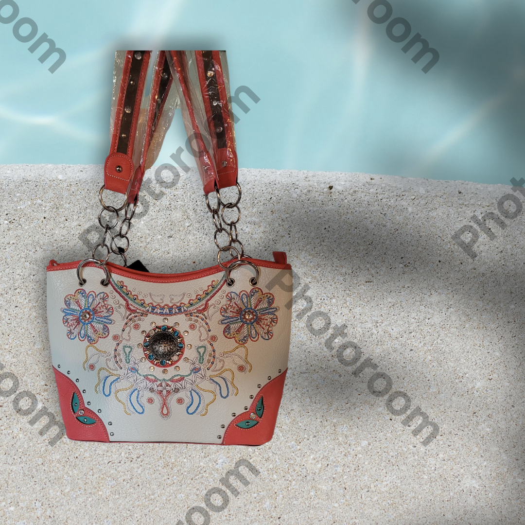 Handbag with floral patterns and red strap on a textured surface