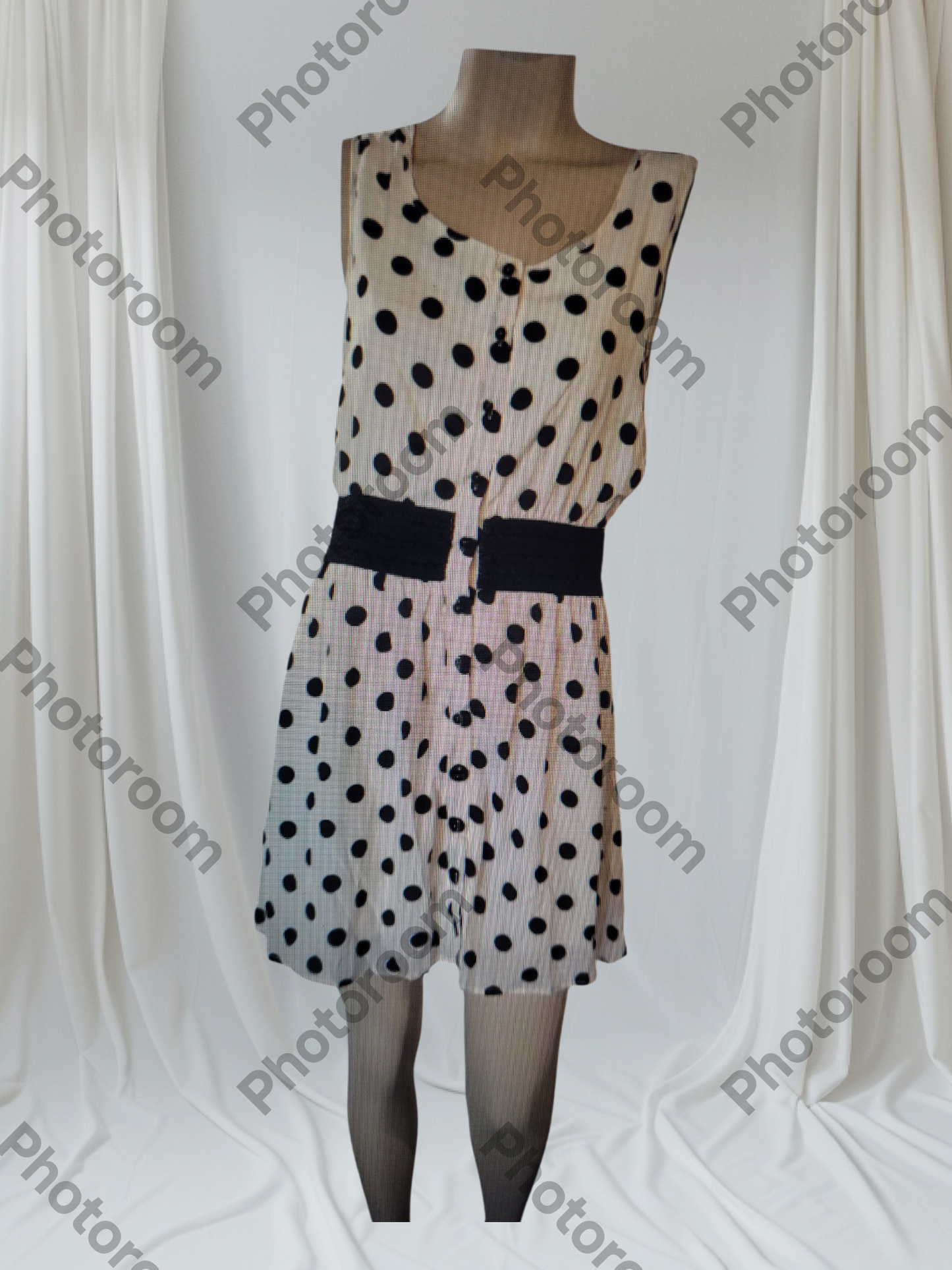 Polka dot dress on a mannequin against a white background with 'Photoroom' watermark.