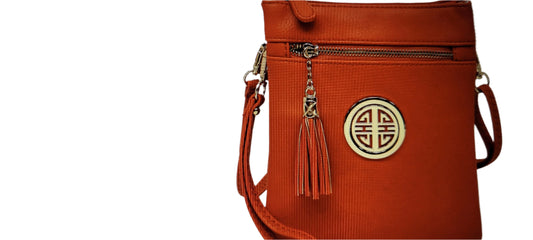 Orange crossbody bag with gold emblem and tassel on a white background