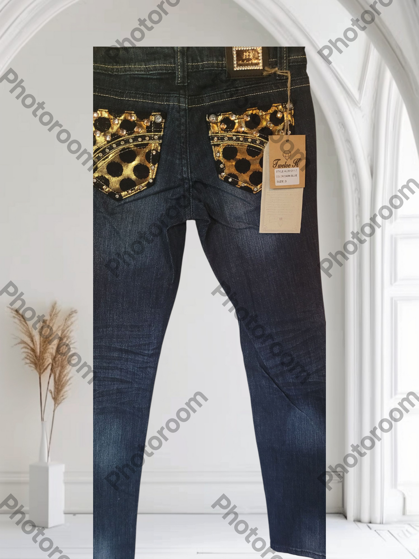 Blue jeans with gold embellishments on a white background