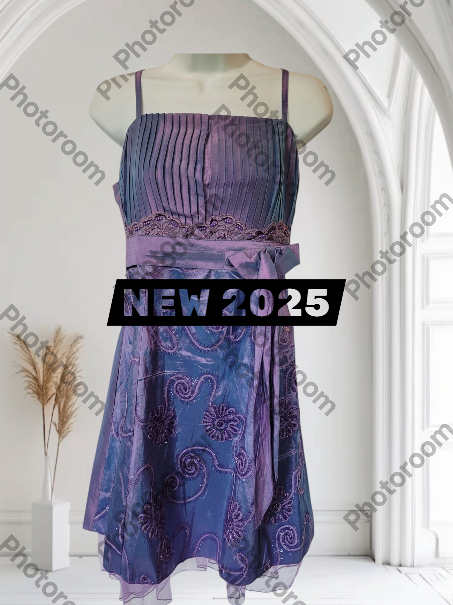 Purple dress on a mannequin with 'NEW 2025' text in a white room.