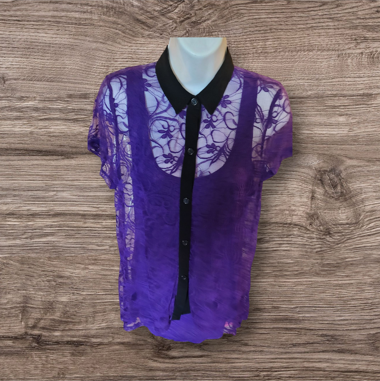 Purple lace blouse with black collar on a mannequin against a wooden background