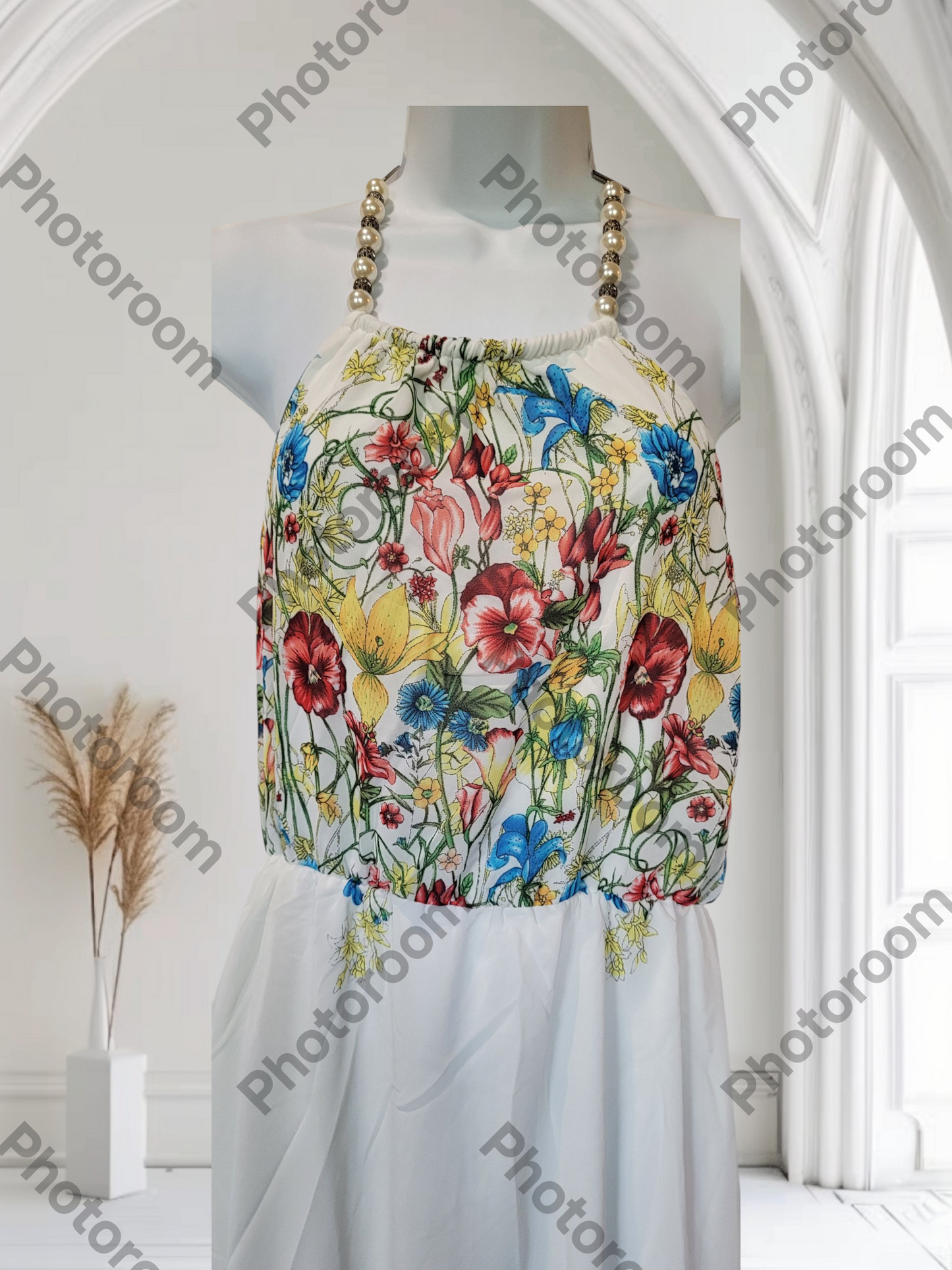 Mannequin wearing a floral dress in a white room with 'Photoroom' watermark.