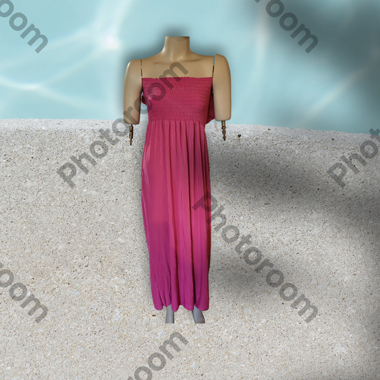 Mannequin wearing a pink dress on a textured surface with 'Photoroom' branding.