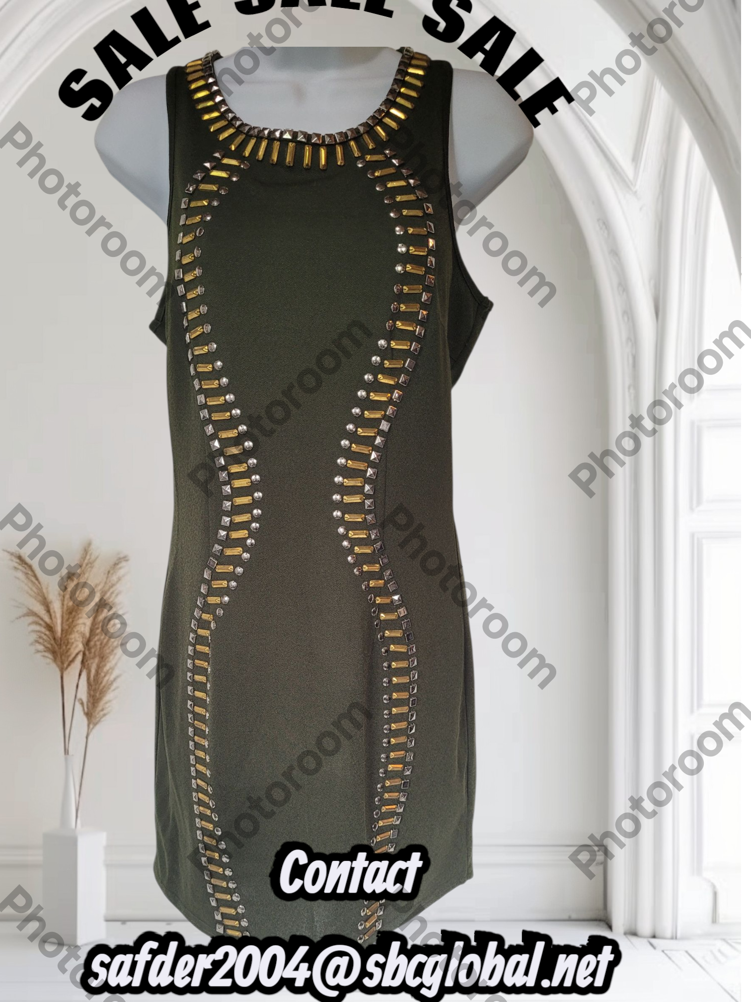 Green dress with gold zipper details on a mannequin against a white background.