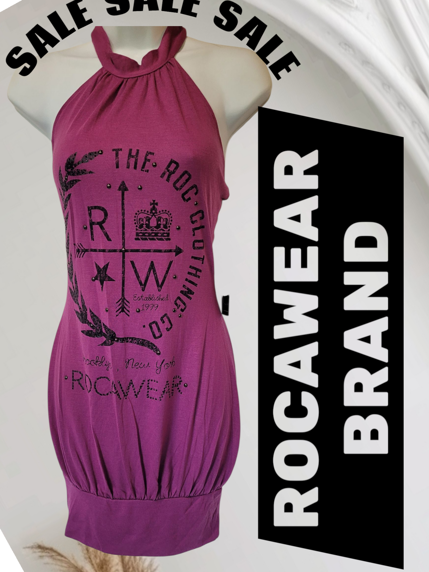 Purple halter dress with branding on a mannequin, surrounded by 'SALE' text and 'ROCAWEAR BRAND' label.